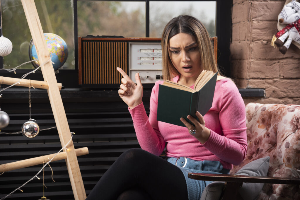 Woman reading a book while experiencing anxiety at home.