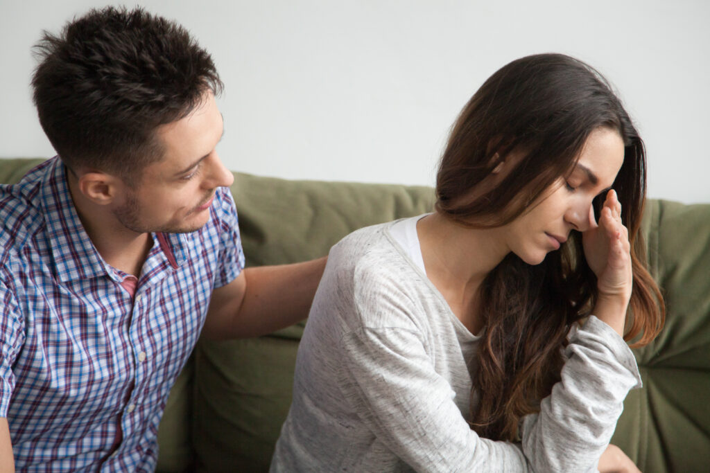 Partner offering emotional support to a distressed woman.