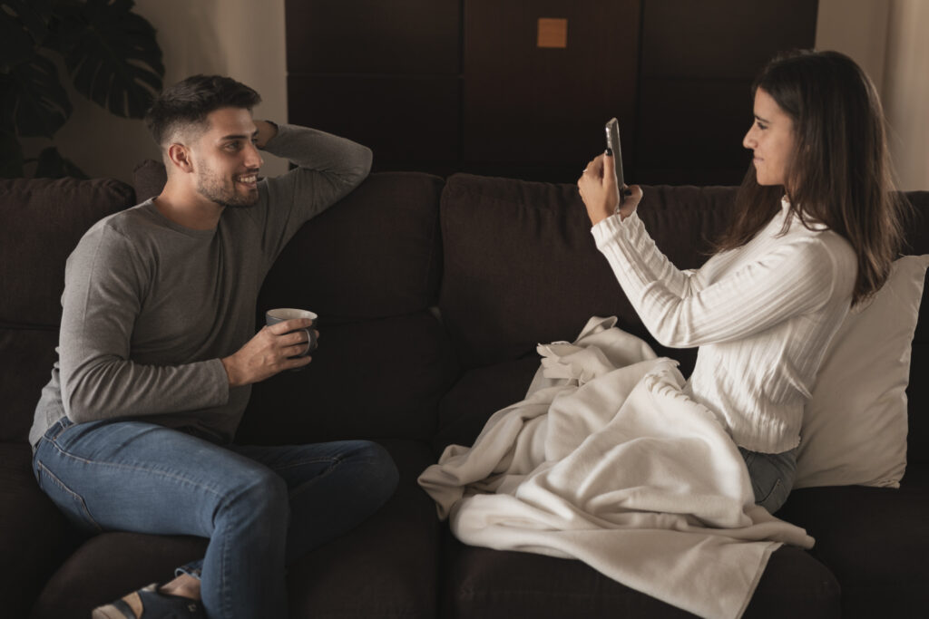 Couple taking a photo together at home, highlighting communication and connection in a relationship.