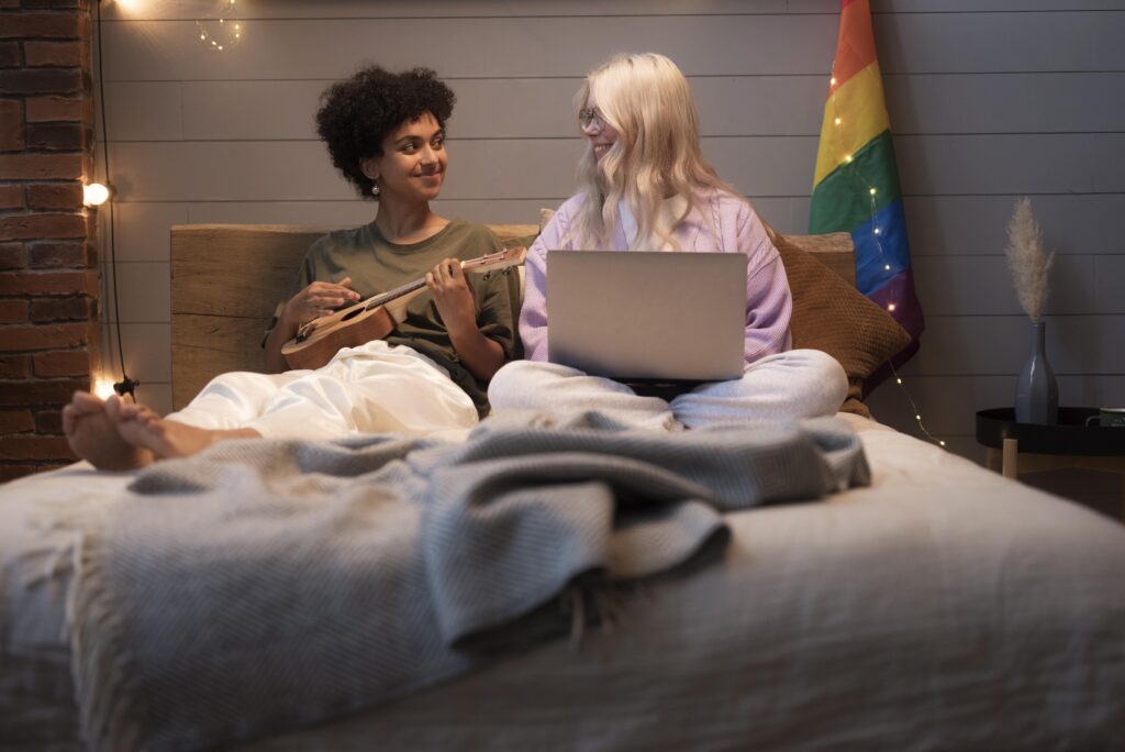 LGBTQ+ couple spending quality time together at home while playing a ukulele.