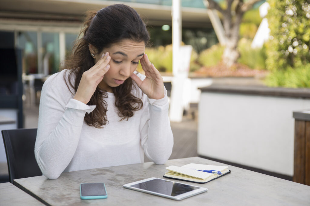 Woman experiencing financial anxiety while sitting at a table