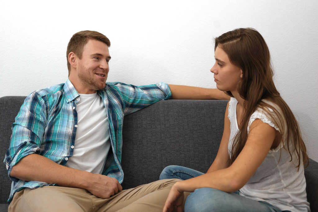 Happy young couple spending quality time together while reading a book at home