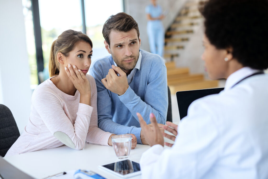 Couple discussing relationship concerns with a therapist during a counseling session.
